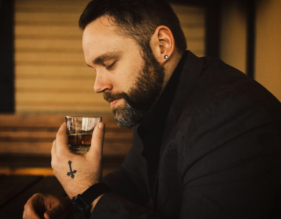 man at whiskey bar drinking bourbon
